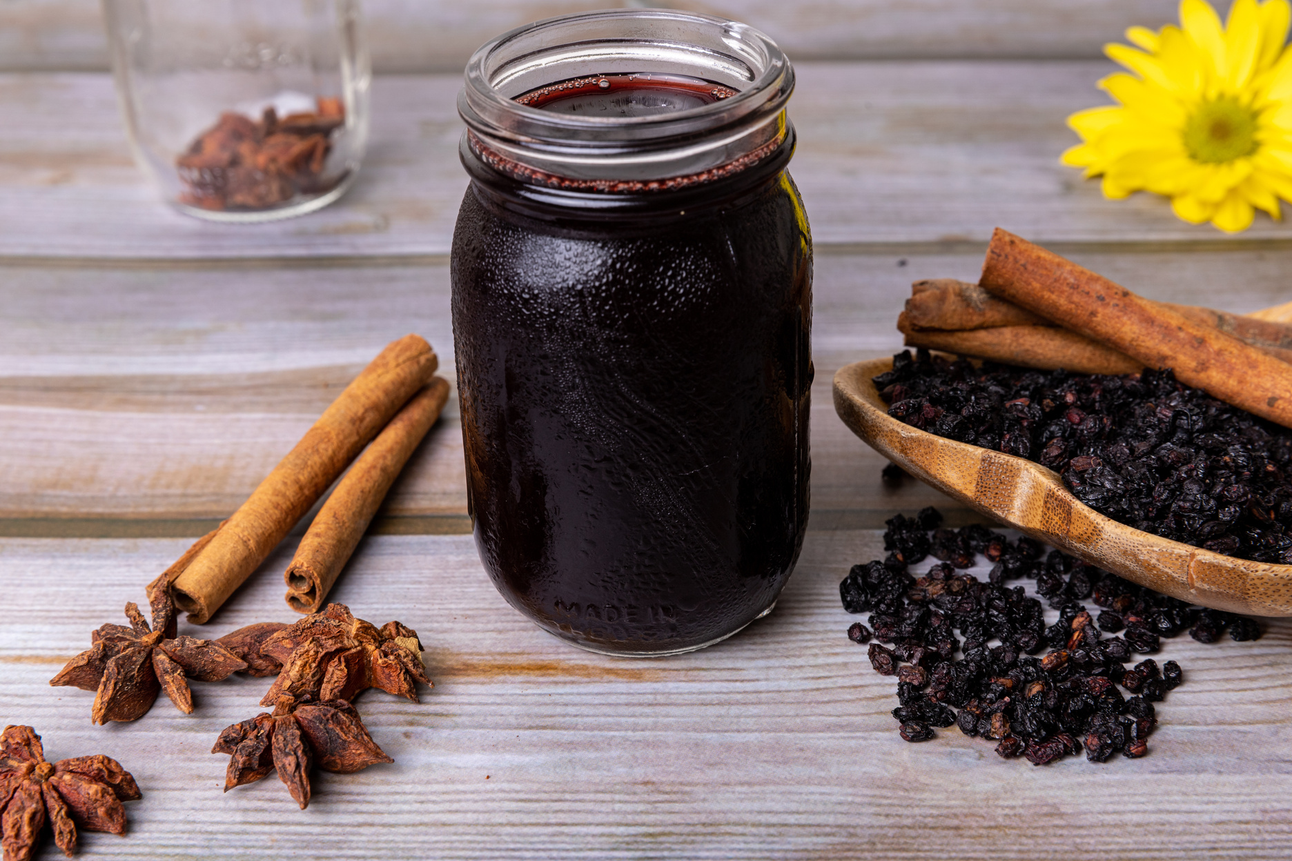 Jar of Elderberry Syrup on a wooden table.